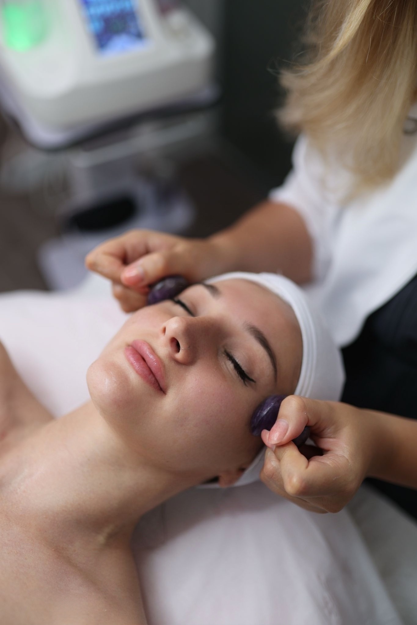Mujer recibiendo tratamiento facial relajante.